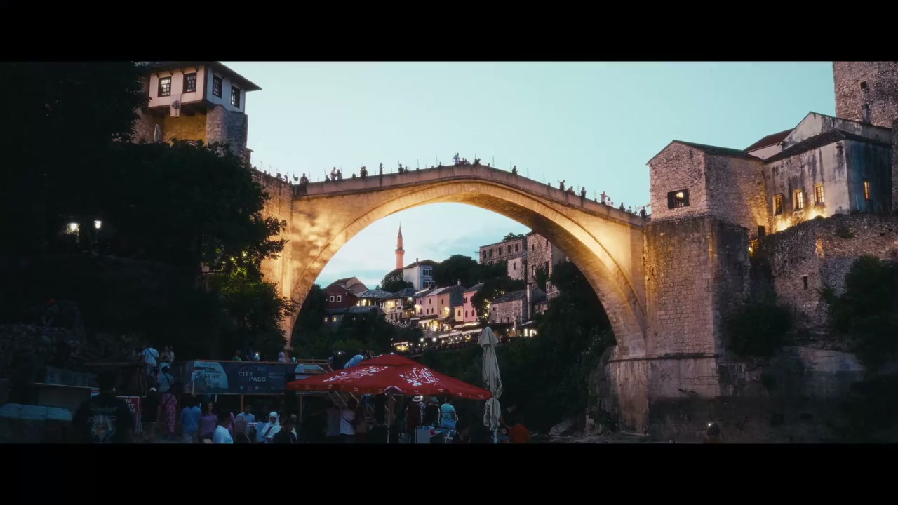 Nihad’s finished frame of Mostar at dusk, with warm buildings above the blue river